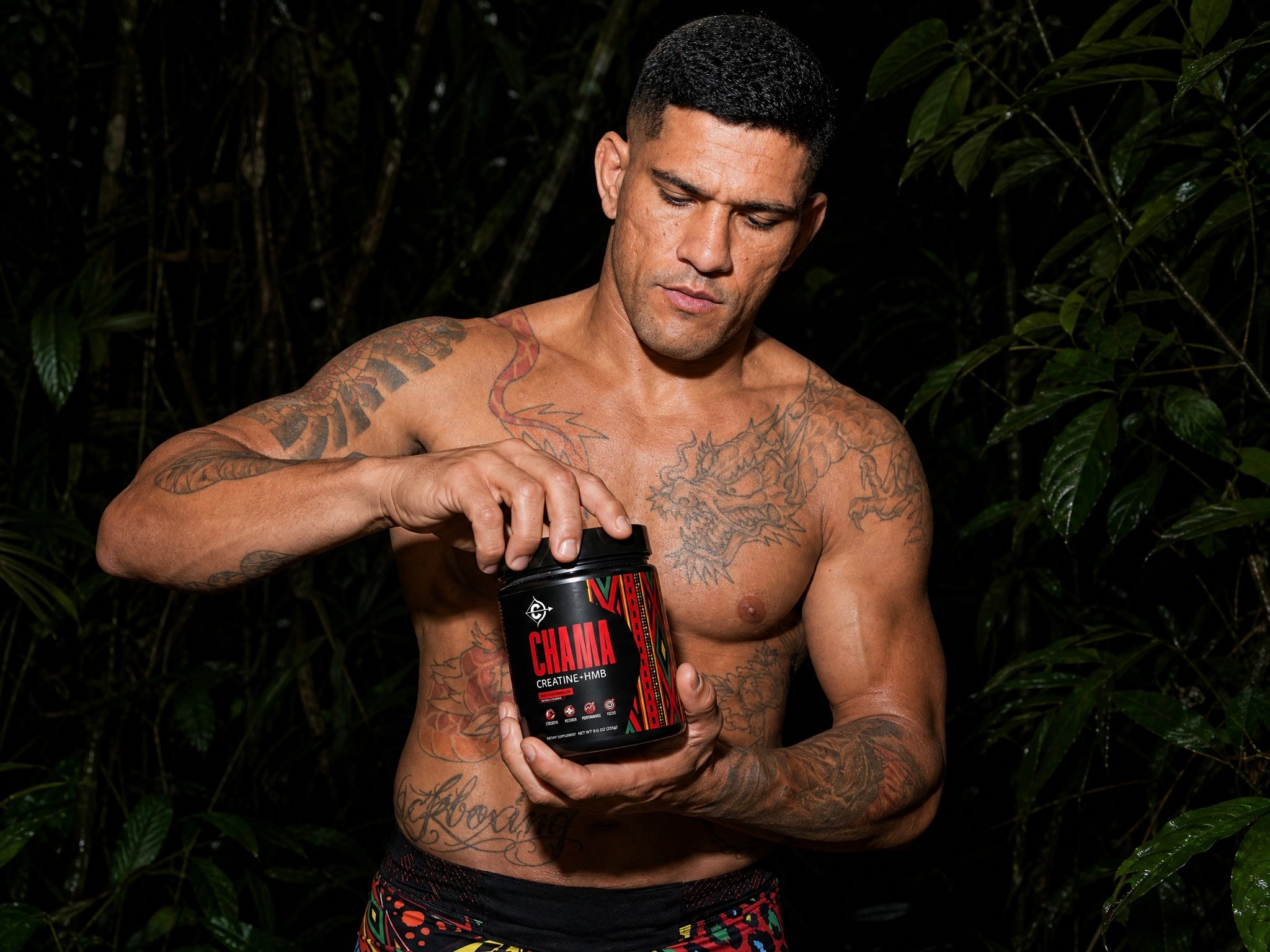 Man holding a chama creatine supplement bottle in a dark, forest-like setting